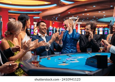 Group of Rich Glamorous People Playing Card at Blackjack Table on a Casino Floor. Celebrating as a Lucky Man Hits the Jackpot after Croupier Dealing a Winning Hand. Cinematic Shot - Powered by Shutterstock