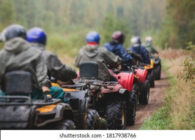 Group of riders riding atv vehicle on off road track, process of driving ATV vehicle, all terrain quad bike vehicle, during offroad competition, crossing a puddle of mud
