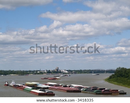 A group of river barges on the Mississippi River transporting cargo downstream.