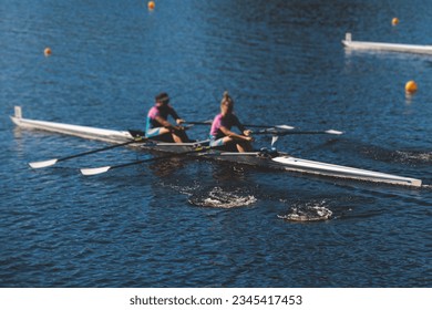 Group of rowing team female girl athletes sculling during competition, kayak boats race in a rowing canal, regatta in a summer sunny day, women canoeing water sports team training in a river - Powered by Shutterstock