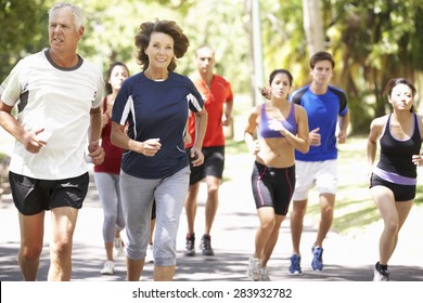 Group Of Runners Jogging Through Park