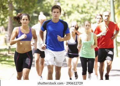 Group Of Runners Jogging Through Park