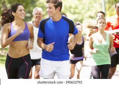 Group Of Runners Jogging Through Park