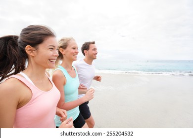 Group Running On Beach Jogging Having Fun Training. Exercising Runners Training Outdoors Living Healthy Active Lifestyle. Multiracial Fitness Runner People Working Out Together Outside Smiling Happy.