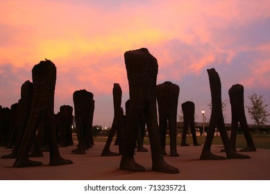 Group of Rusting Iron Headless Figure statues  in Grant Park with twilight sky at dusk in downtown Chicago, IL, USA.