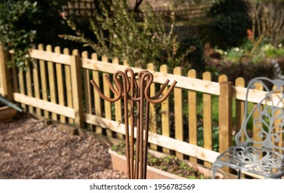 Group Of Rusty Shepherds Crook Gardening Stakes On A Bright Sunny Spring Day In A Vegetable Garden In Rural Devon, England, UK