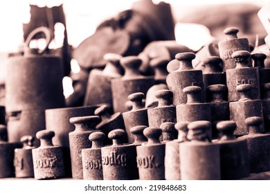 Group of rusty vintage weights. Selective focus. Low depth of field. Black and white photography. Sepia. Cream tone.
