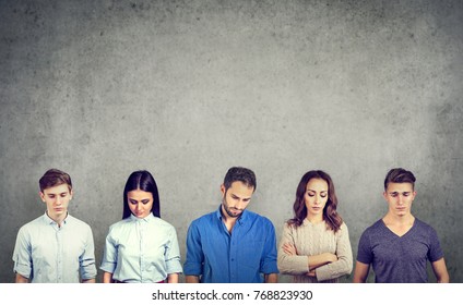 Group Of Sad Unhappy People Men And Women Standing Against Gray Wall Looking Down. Negative Human Emotions 