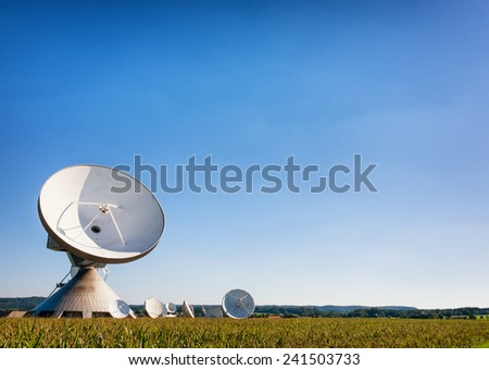 group of satelite dishes in front of blue sky