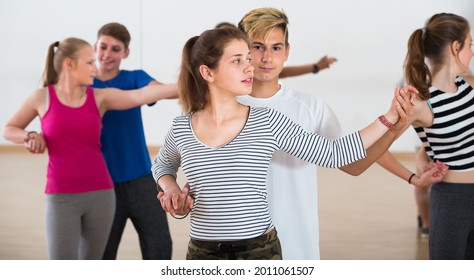 Group Of Satisfied Teen Learning To Dancing Tango In Dance Studio