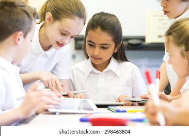 A Group Of School Children Can Be Seen Working On Digital Tablets, They Are All Working Happily.