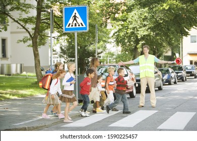 Group Of School Children Crossing Street At Crosswalk