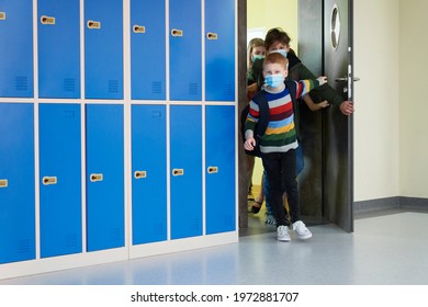 Group of school children leave the class wearing protective masks - Powered by Shutterstock