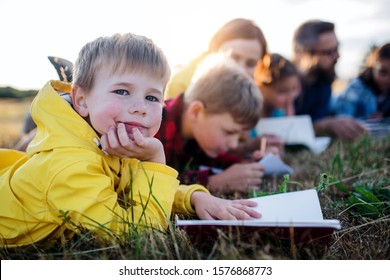 Group Of School Children With Teacher On Field Trip In Nature.