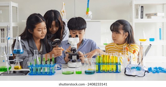 Group of school children using microscopes to study science at school