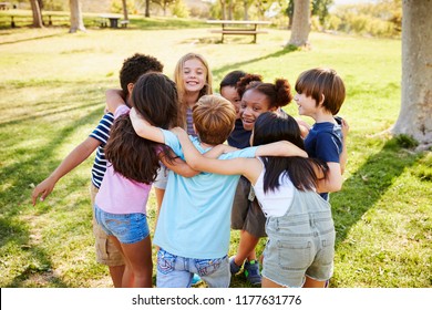 A Group Of School Kids In A Huddle Outdoors, Back View