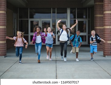 Group Of School Kids Running As They Leave The School Building Back To School Photo Of A Diverse Group Of Children Wearing Backpacks And Ready To Go Home From School