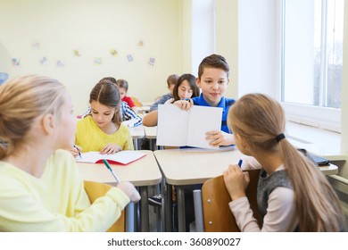 Group Of School Kids Writing Test In Classroom