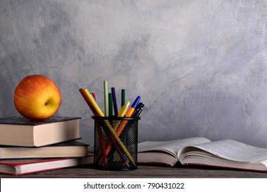 Group Of School Supplies And Books On Wooden Table Over A Grey Background