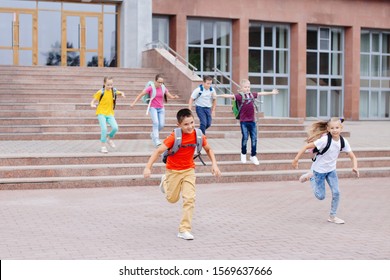 Group of schoolchildren with backpacks run upstairs from school after lesson. - Powered by Shutterstock