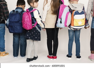 Group Of Schoolers Kids With Backpack Behind Rear View On White Blackground