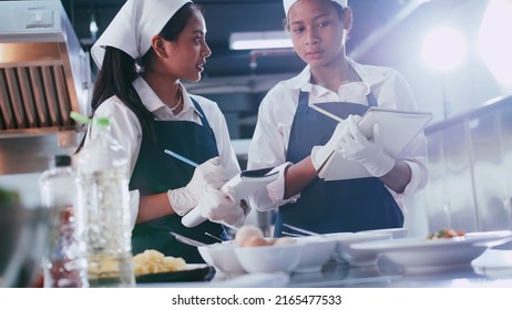 Group of schoolgirls having fun learning to cook. Female students in a cooking class. - Shutterstock ID 2165477533