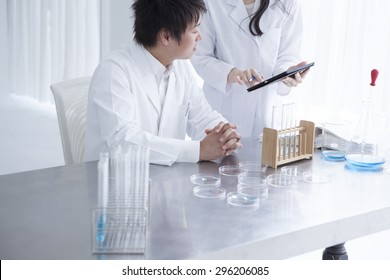 Group of scientists with tablet PC working on an experiment at the laboratory