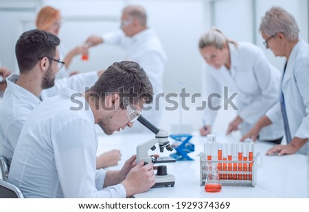 group of scientists using microscopes to study blood.