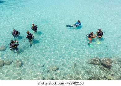 A group of Scuba Diving students have a lesson in shallow crystal clear water of a Tropical Island