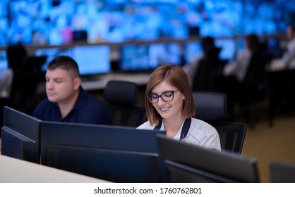 Group of Security data center operators working in a CCTV monitoring room looking on multiple monitors  Officers Monitoring Multiple Screens for Suspicious Activities  Team working on the System Contr
