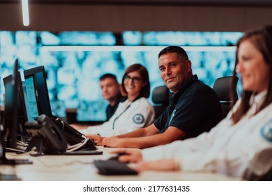 Group of Security data center operators working in a CCTV monitoring room looking on multiple monitors Officers Monitoring Multiple Screens for Suspicious Activities Team working on the System Contr