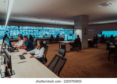 Group of Security data center operators working in a CCTV monitoring room looking on multiple monitors Officers Monitoring Multiple Screens for Suspicious Activities Team working on the System Contr