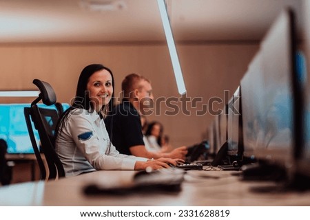 Group of Security data center operators working in a CCTV monitoring room looking on multiple monitors.Officers Monitoring Multiple Screens for Suspicious Activities