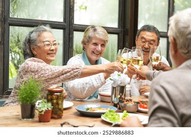 Group of senior adults enjoy meal, toasting with wine. Diverse group of senior friends share joyful moment at dining table, celebrating together with wine. Diverse senior adult friends celebrating. - Powered by Shutterstock