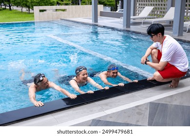 Group of senior asian friend is learning how to swim at the swimming pool with professional trainer for retirement exercise workout activities and healthy wellbeing concept - Powered by Shutterstock