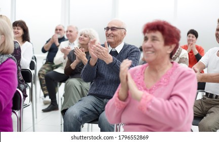 a group of senior citizens applaud in the conference room - Powered by Shutterstock