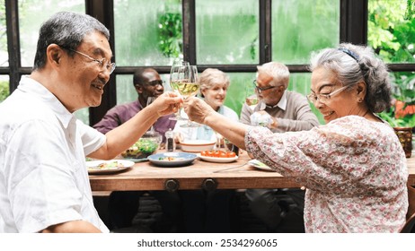 Group of senior enjoying a meal, toasting with wine. Diverse seniors, happy and smiling, sharing a joyful moment. Celebrating together, enjoying life. Group of happy senior people are toasting. - Powered by Shutterstock