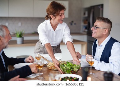 Group Of Senior Friends At Dinner Party At Home.