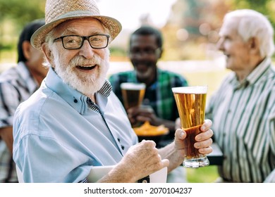 Group Of Senior Friends Drinking A Beer At The Park. Lifestyle Concepts About Seniority And Third Age