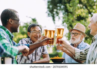 Group Of Senior Friends Drinking A Beer At The Park. Lifestyle Concepts About Seniority And Third Age