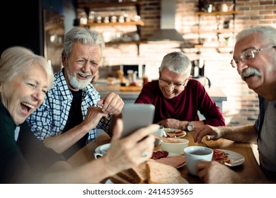 Group of senior friends enjoying conversation and breakfast together - Powered by Shutterstock