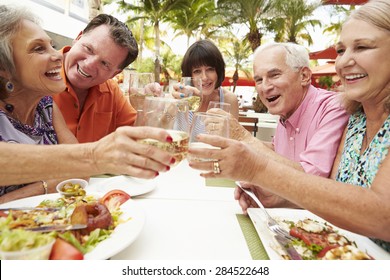 Group Of Senior Friends Enjoying Meal In Outdoor Restaurant