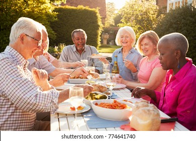 Group Of Senior Friends Enjoying Outdoor Dinner Party At Home