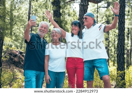 Group of Senior Friends Enjoying Trekking Day on Forest - Elderly Caucasian Men and Women Take Selfie with Smartphone - Freedon, Sport, Healthy Lifestyle Concept