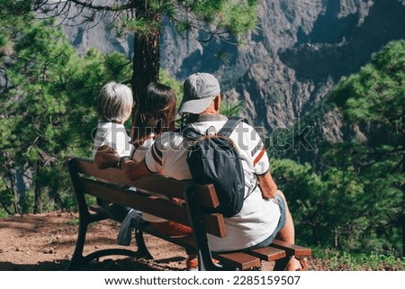 Group of Senior Friends Enjoying Trekking Day on Mountain - Elderly Caucasian Man and Women Sitting on Bench Admiring Landscape - Freedon, Sport, Healthy Lifestyle Concept