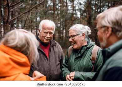 Group of senior friends laughing together on forest hike in raincoats - Powered by Shutterstock