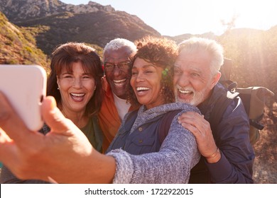 Group Of Senior Friends Posing For Selfie As They Hike Along Trail In Countryside Together - Powered by Shutterstock