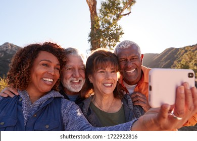 Group Of Senior Friends Posing For Selfie As They Hike Along Trail In Countryside Together - Powered by Shutterstock