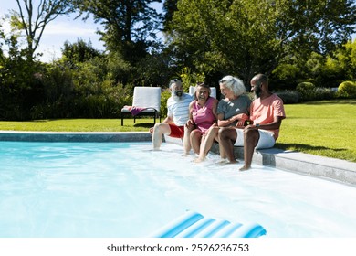 Group of senior friends sitting by pool, enjoying sunny day together. seniors, leisure, poolside, relaxation, summer, outdoors, unaltered - Powered by Shutterstock