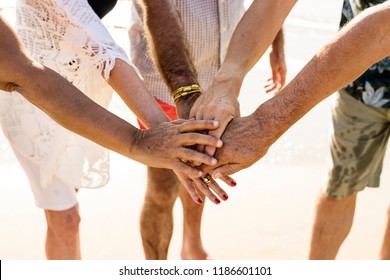 Group of senior friends stacking hands - Powered by Shutterstock